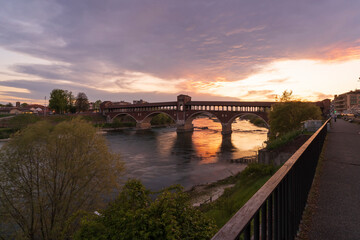 Ponte Coperto (covered bridge) over Ticino river in Pavia at sunset, Lombardy, italy.
