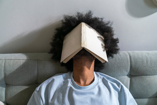 Man with curly hair sleeping on sofa at home