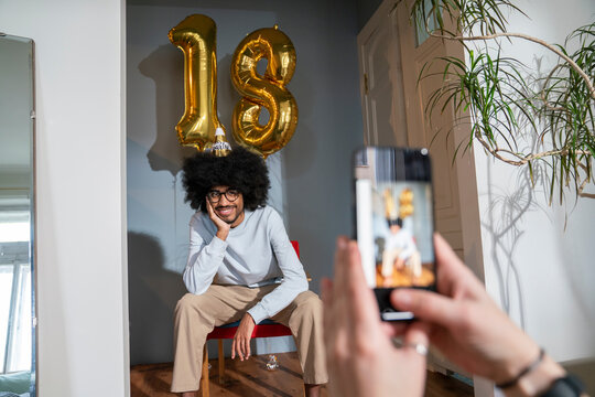 Woman photographing friend celebrating birthday at home