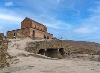 Ancient church monastery at the top of caves city build in rocks at Uplistsikhe Georgia with blue sky. Historical place near Gori.