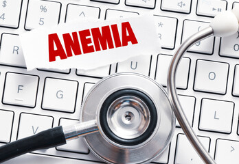 Anemia word on a small piece of paper placed on a computer keyboard next to a stethoscope.