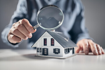 House model with man holding magnifying glass home inspection or searching for a house - 612242889