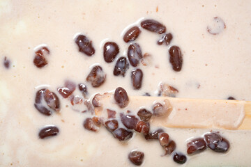 top view melted red bean and condensed milk flavor popsicle on green background