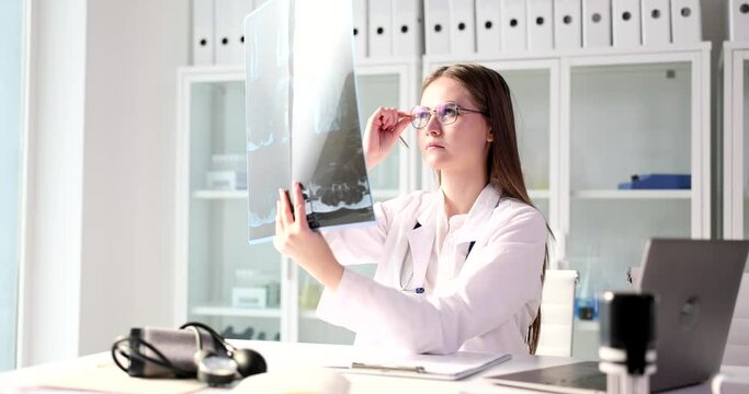 Physician or surgeon looking at x-ray image of body. Examining computed tomography MRI in clinic