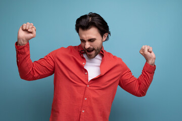Fototapeta premium handsome young brunette man in red shirt dancing