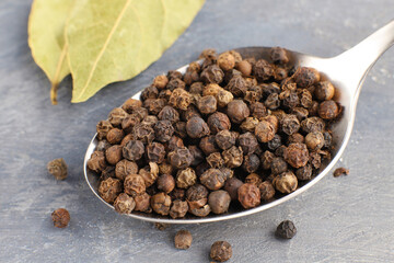 Dried black pepper on gray background