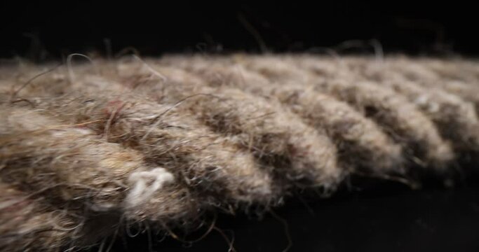 Coil of brown rope on a black background. Polyamide braided rope