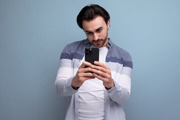 happy joyful brunette guy in casual style takes photo using phone