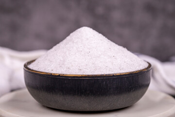 Non-iodized salt on dark background. Natural minaret non-iodized grinding salt in bowl. Spice concept. Close up