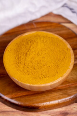 Curry powder on wooden background. Curry powder in wooden bowl. Mixture of spices and dried herbs. Spice concept
