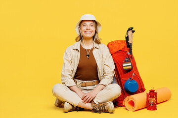 Full body smiling happy young woman carry bag with stuff mat sit look camera isolated on plain...