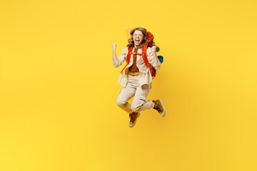 Fototapeta na wymiar Full body young woman carry bag with stuff mat jump high do winner gesture isolated on plain yellow background. Tourist leads active lifestyle walk on spare time. Hiking trek rest travel trip concept.