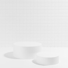 Summer abstract white stage mockup with two cylinder podiums in sun hard light, shadow, template for presentation cosmetic products, spa, goods, showing, tiny mosaic tile in mediterranean style.