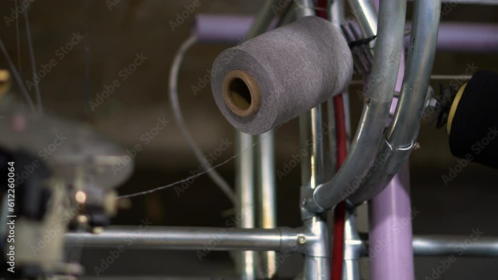 Poster close-up shot of spools with grey thread at rewinding machine video - close-up parts of the machine 