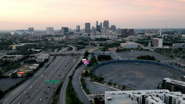 Atlanta, Georgia skyline at dusk with freeway traffic and drone video moving in a circle.