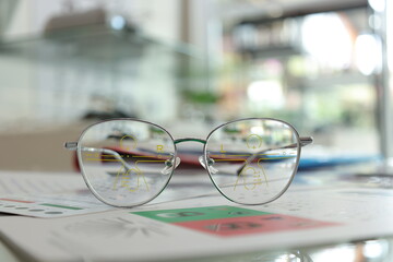 Fototapeta na wymiar glasses on the paper chart, Eyeglass in optical shop, progressive lenses, eyeglasses for the elderly, glasses progressive lens 
