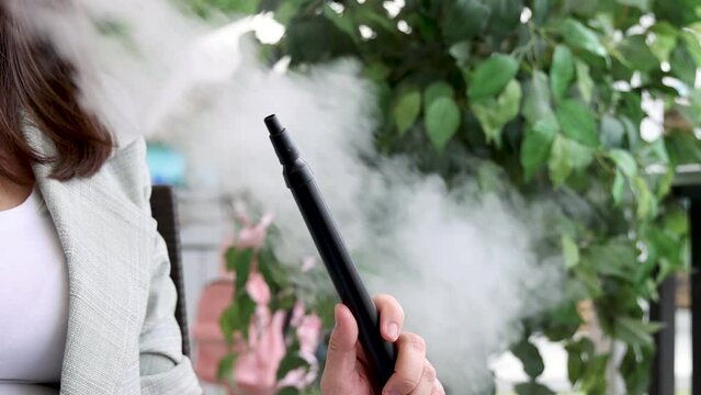 girl woman smoking hookah in terrace restaurant sitting with coffee cup on table,typing message on phone.female with cold sore herpes hpv virus on lips 4k.hookan man putting coal cubes on tabaco bowl