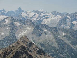 Aerial panoramic view of the Main Caucasus Mountain Ridge from Mount Elbrus, the highest summit in Europe, glacier Seven, incredible blue sky background, impressive nature landscape in North Caucasus