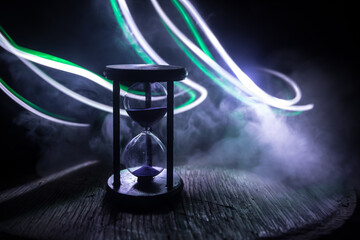 Hourglass as time passing concept for business deadline, urgency and running out of time. Sandglass, egg timer on dark background showing the last second or last minute or time out.