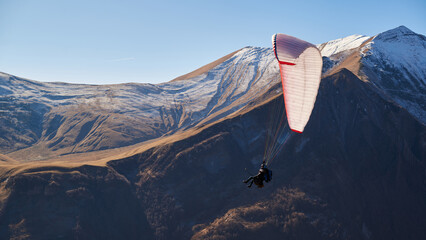 paraglider with a white wing close-up against the background of high-peak snowy mountains. clear...
