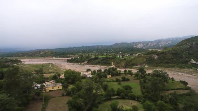 Outside river valley and distant cityscape view through the window of a moving train while traveling to Mata Vaishno Devi Shrine. Katra Express Jammu And Kashmir.