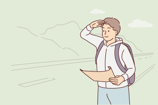 Man forwarder with map stands near road and looks into distance waiting for arrival bus for tourists