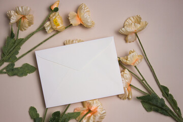 A white envelop with flowers over the light background. 