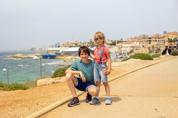 European tourist family with children, visiting Tel Aviv, Israel, enjoying day walk