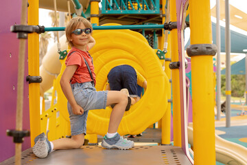 Happy children, boys, playing on playground in Tel Aviv, israel on hot summer day