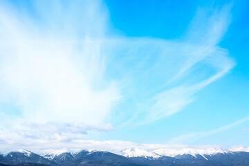 Snow covered mountain peaks and blue sky with clouds, concept environment background