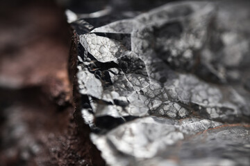 Metal rock texture. Close up of a raw hematite stone. Shiny mineral with an abstract pattern.	