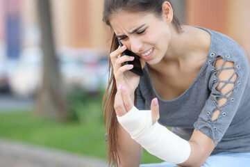 Convalescent woman with bandaged arm calling on phone