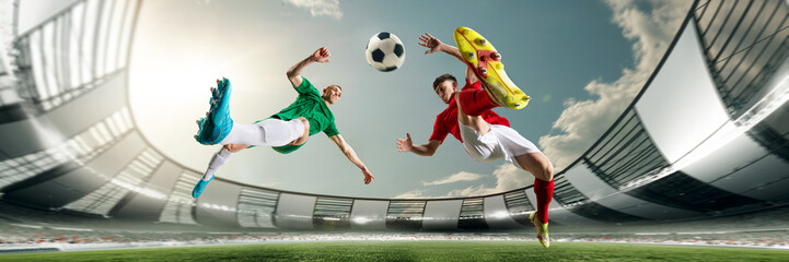 Bottom view of two football players in motions during game at 3D open playground, arena, kicking ball in jump. Concept of professional sport, championship, game, achievement. Banner, flyer. Ad