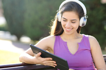 Happy woman watching media on tablet with headphone