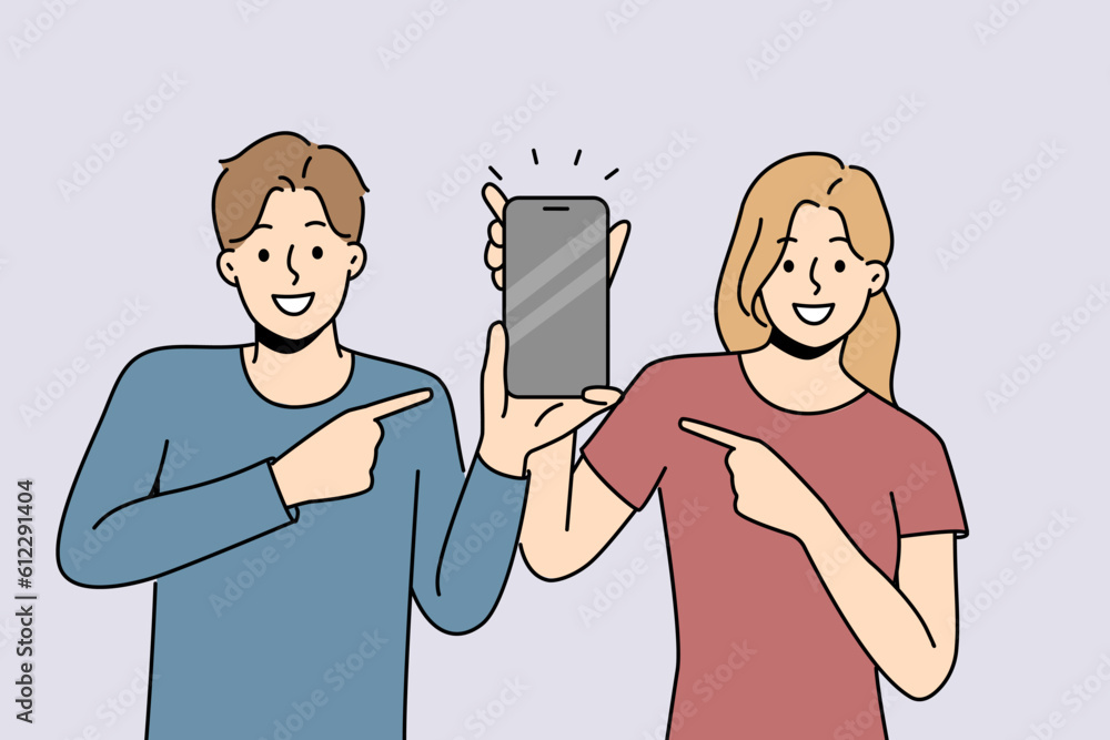 Poster smiling couple point at cellphone with empty screen. happy man and woman point with finger on smartp
