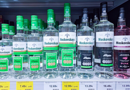 LATVIA, RIGA, MAY, 2023: Glass bottles of Moskovskaya vodka on supermarket shelf. Bottled strong alcoholic beverages ready for sale.