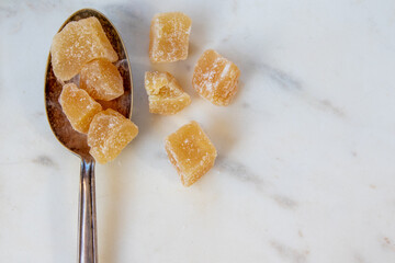 Pieces of uncrystallised ginger on a silver spoon. 