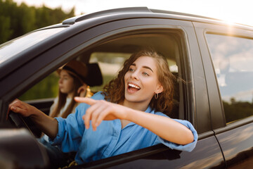 Two young women on car trip having fun. Lifestyle, travel, tourism, nature, active life.