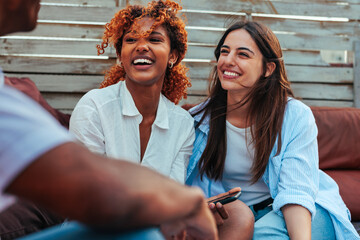 Portrait of two diverse girl friends having fun conversation