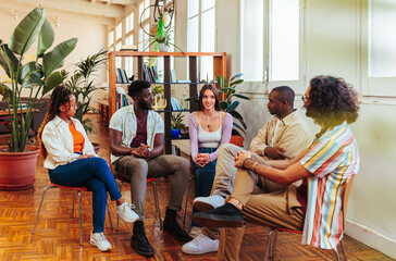 Five diverse young people on group therapy session