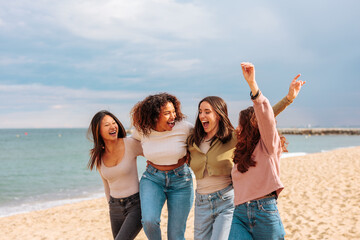 Diverse young women having fun on beach.