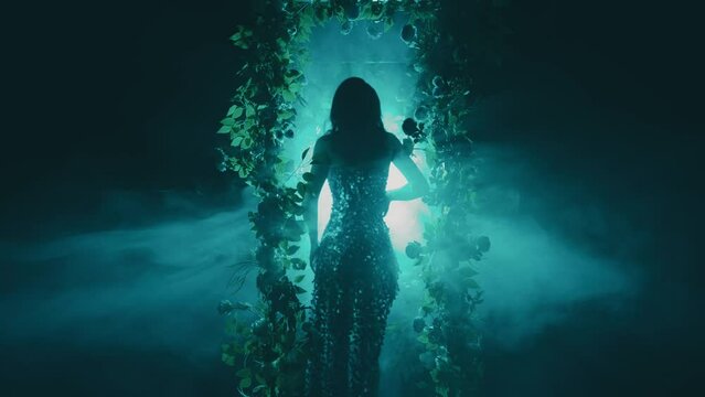 dark shadow mysterious silhouette fantasy woman walking in black night garden in fog fairytale portal arch flowers, art neon blue magic light. Mystery lady Gothic Girl princess in smoke back rear view