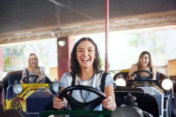 Deurstickers Portrait smiling young woman riding bumper cars at amusement park © KOTO