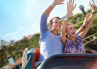 Exhilarated young couple riding amusement park ride