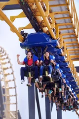 Photo sur Plexiglas Parc dattractions Young man cheering on amusement park ride