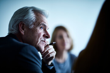 Attentive senior businessman listening in meeting