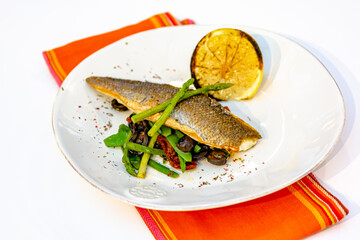 Grilled spicy fish served with asparagus and green beans.Colorful food art composition on plate.