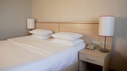 Fototapeta na wymiar double bed in a hotel room. Hotel luxury double bedroom. hotel room bed. White bedspread on a double bed in a hotel room.