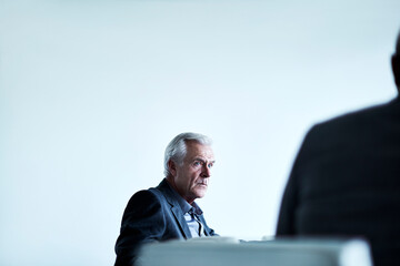 Serious senior businessman listening in meeting