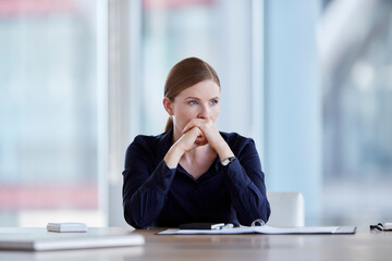 Pensive businesswoman looking away in conference room